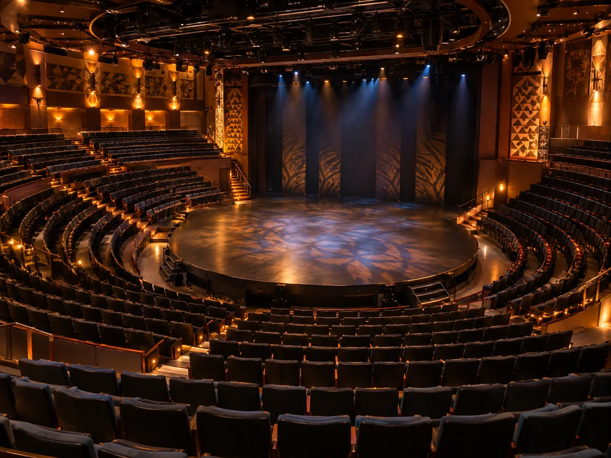 Rangées de sièges incurvées autour d'une scène ronde en avancée, dans un théâtre intimiste